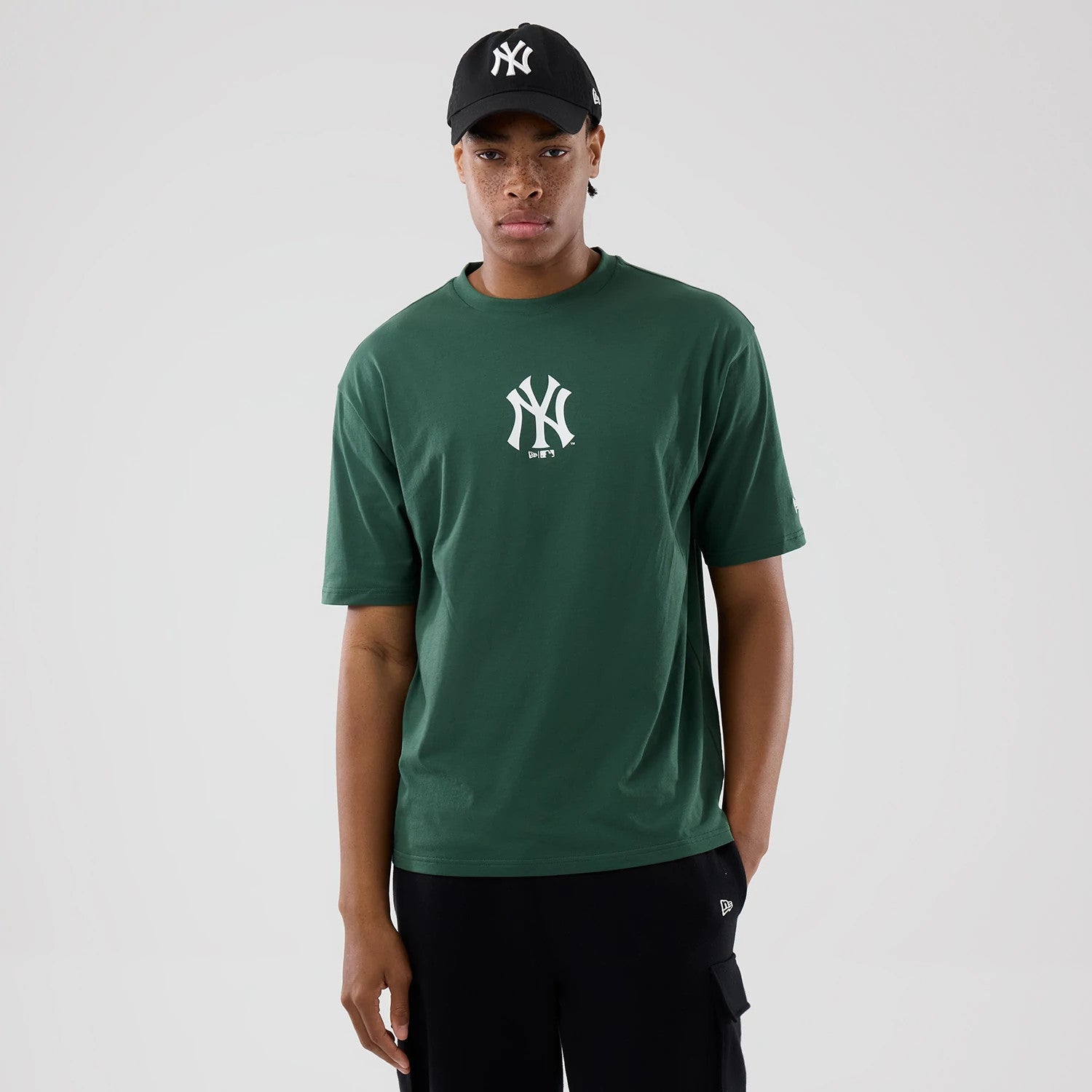 The model is wearing this MLB Food Graphic New York Yankees Oversized T-Shirt in dark green. 1