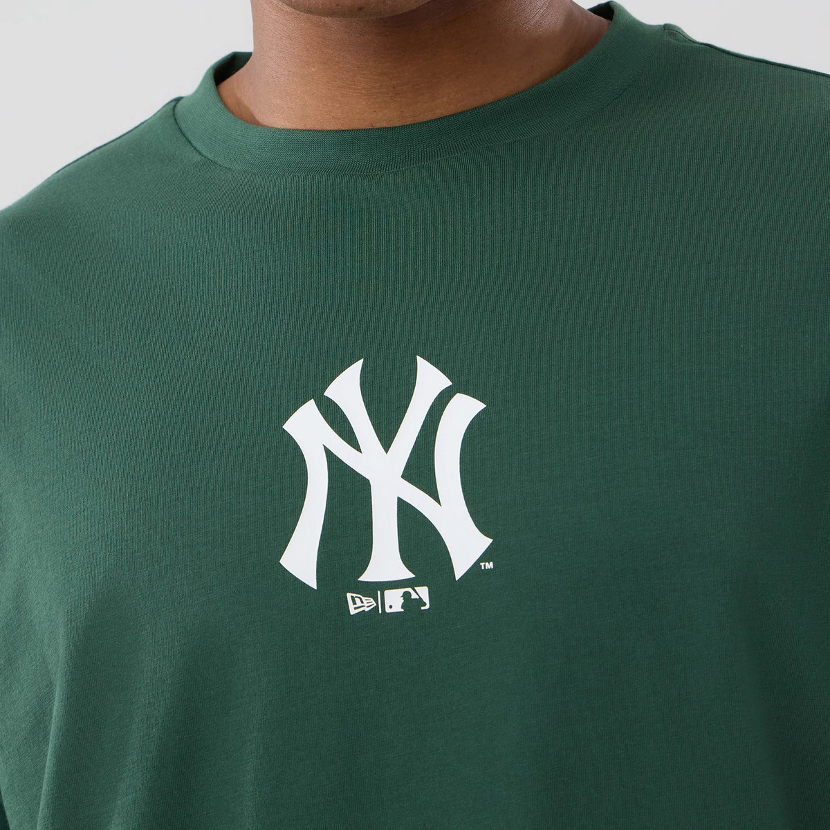 New Era New York Yankees MLB Food Graphic Dark Green Oversized T-Shirt, front view on-model highlighting the white embroidered New York Yankees logo centred on the chest, set against the dark green fabric of the oversized t-shirt.