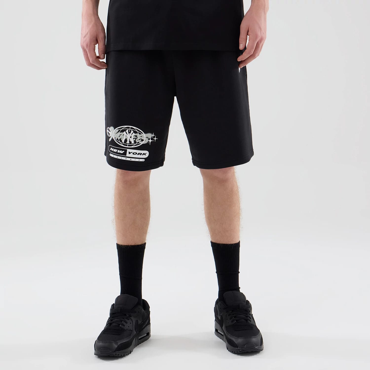 The model is wearing these MLB Logo Graphic New York Yankees Oversized Shorts in black. 1