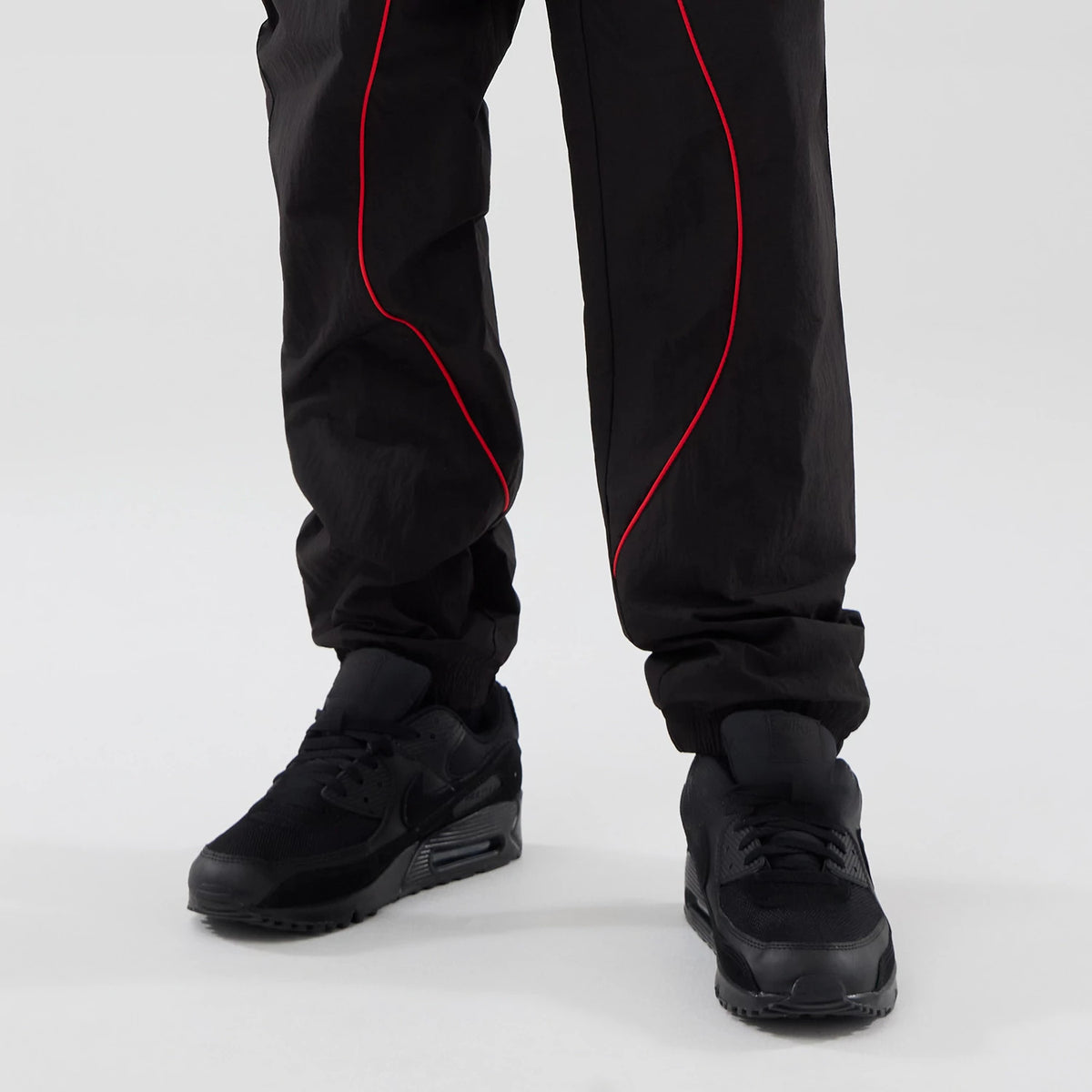 The model is wearing these Red Bull Racing Piping Track Pants in black. 7