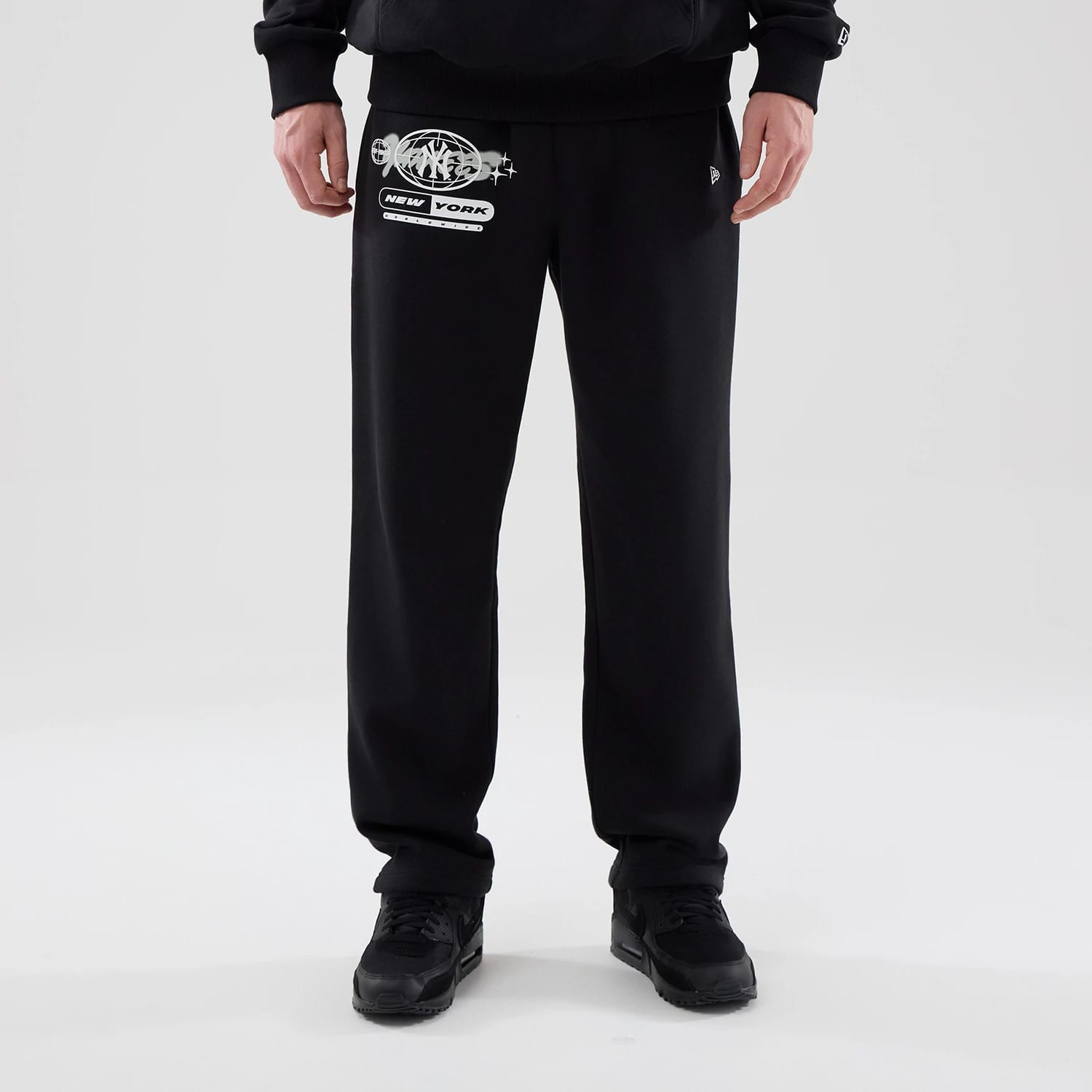 The model is wearing these MLB Logo Graphic New York Yankees Straight Leg Joggers in black. 1