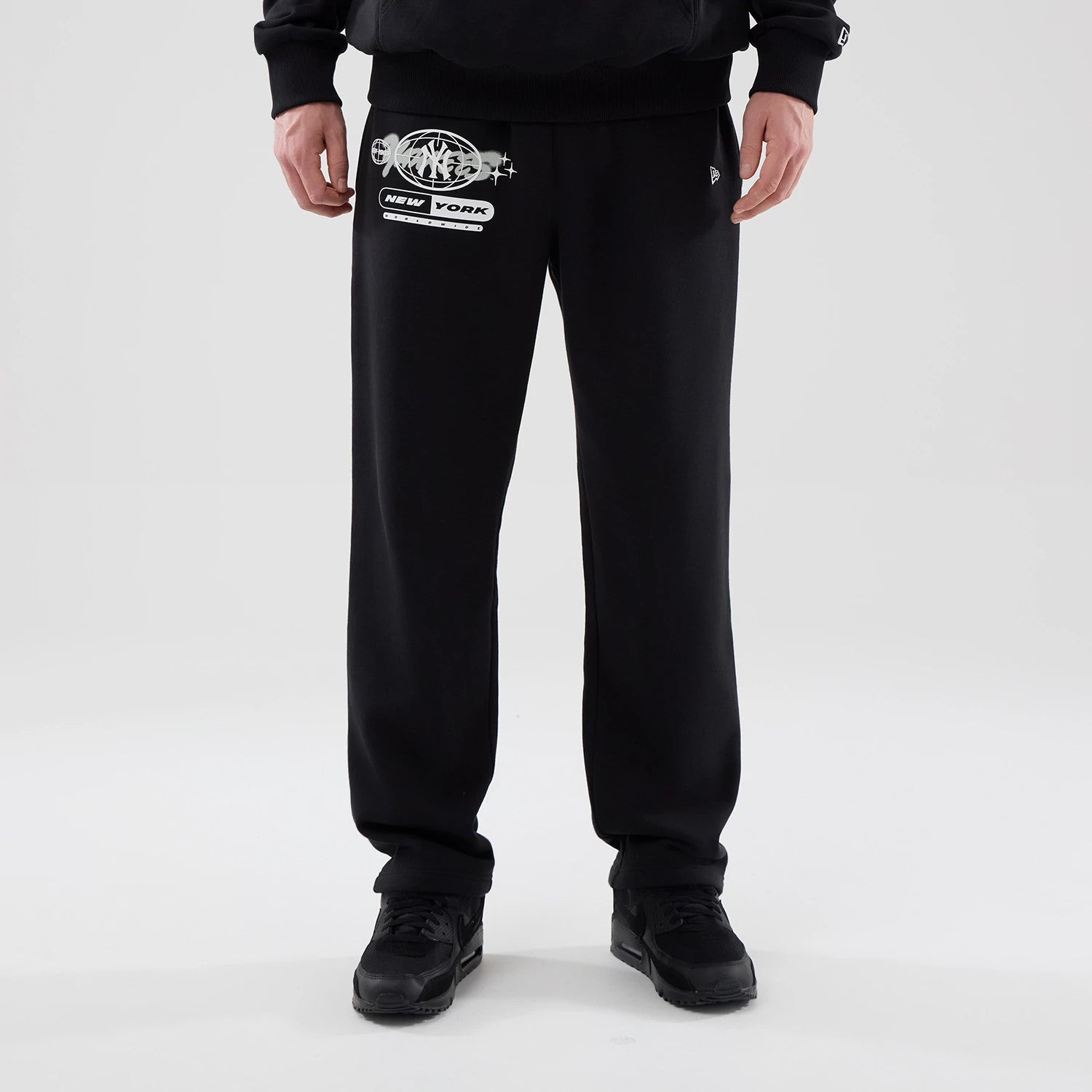 The model is wearing these MLB Logo Graphic New York Yankees Straight Leg Joggers in black. 1