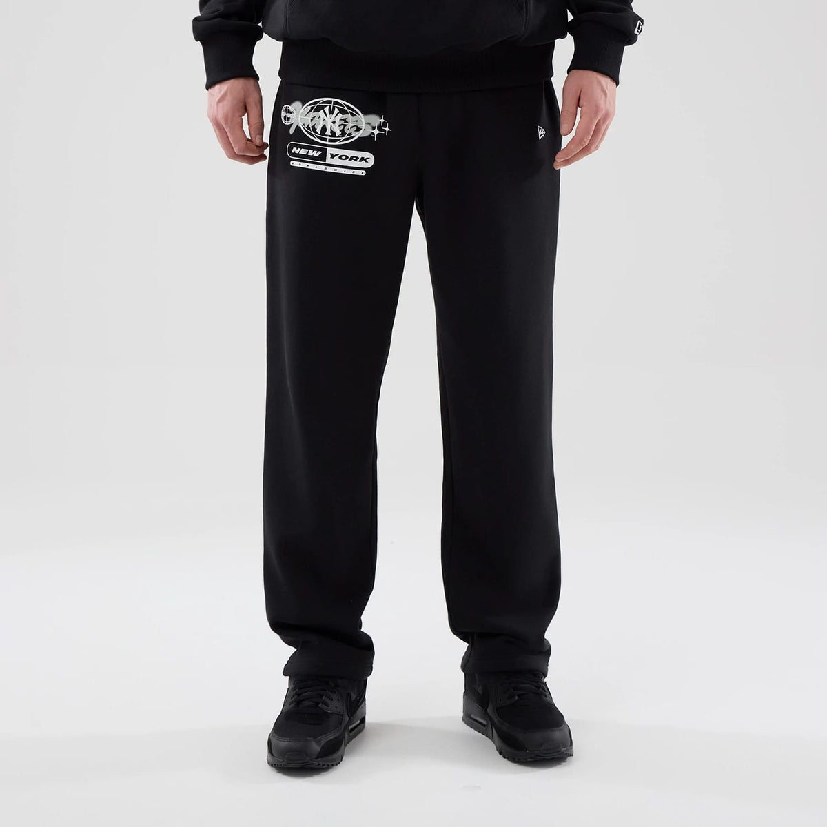 The model is wearing these MLB Logo Graphic New York Yankees Straight Leg Joggers in black. 1