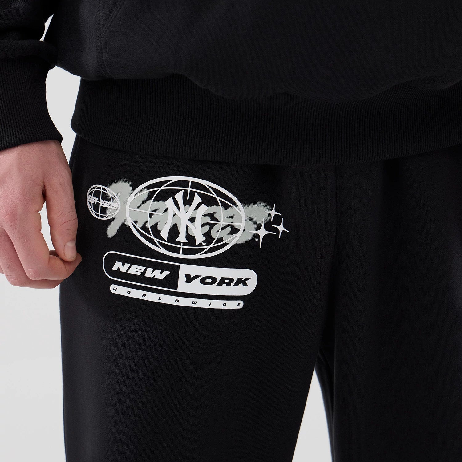 The model is wearing these MLB Logo Graphic New York Yankees Straight Leg Joggers in black. 4