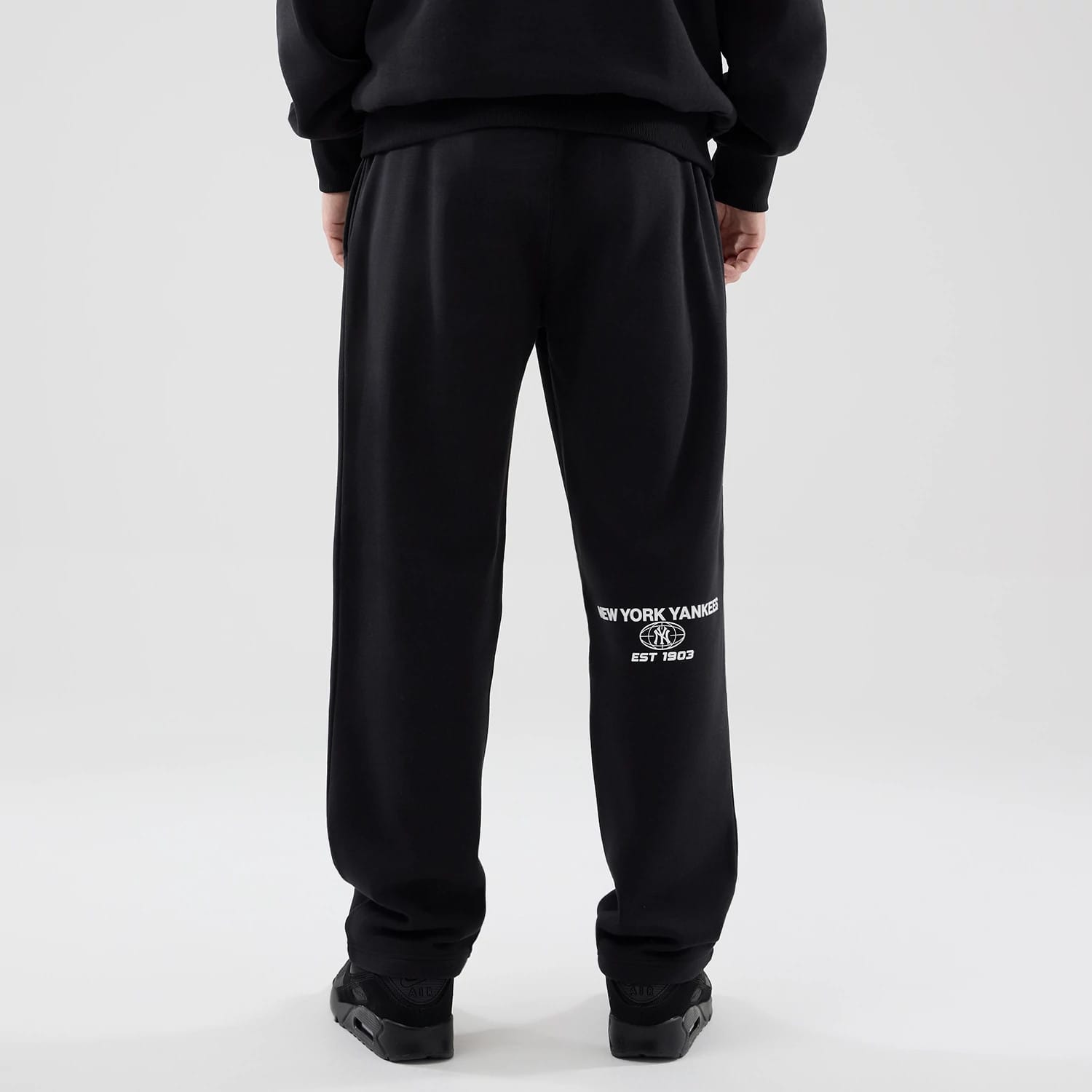 The model is wearing these MLB Logo Graphic New York Yankees Straight Leg Joggers in black. 2