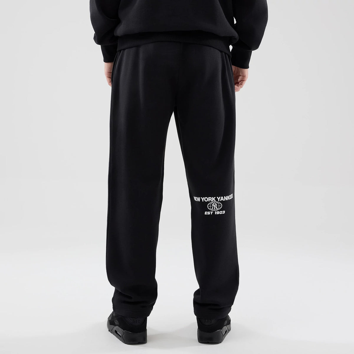 The model is wearing these MLB Logo Graphic New York Yankees Straight Leg Joggers in black. 2