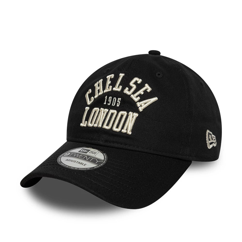 Chelsea FC Script Black New Era 9TWENTY Adjustable Cap, front view showing raised white script embroidery reading Chelsea London 1905 on the structured black crown, curved visor with a 9TWENTY size sticker, and the New Era flag logo on the left side.