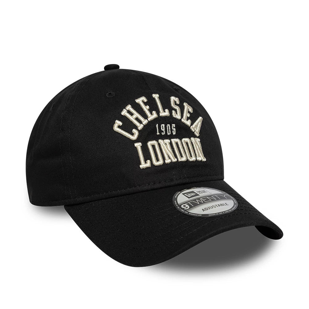 Chelsea FC Script Black New Era 9TWENTY Adjustable Cap, three-quarter view showing raised white embroidered 'Chelsea London 1905' script on the front panel, with a slightly curved black visor and a 9TWENTY size sticker on top.