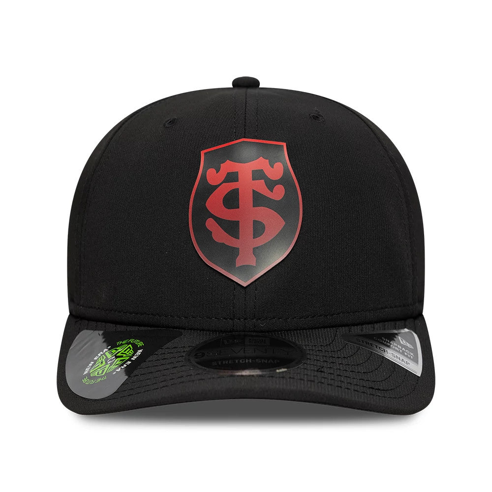 Stade Toulousain Gradient Black New Era 9SEVENTY Stretch Snap Adjustable Cap, front view showing a red and black gradient Stade Toulousain shield logo on the structured black crown, with two size stickers on the curved black visor.