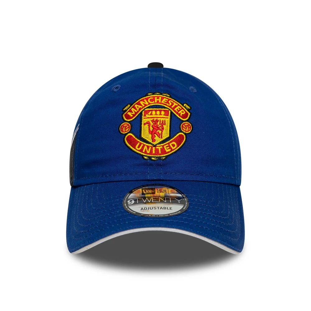 Manchester United FC 96 Blue New Era 9TWENTY Adjustable Cap, front view showing the red and yellow embroidered club crest on the structured blue crown, with a curved visor and 9TWENTY size sticker on the grey undervisor.