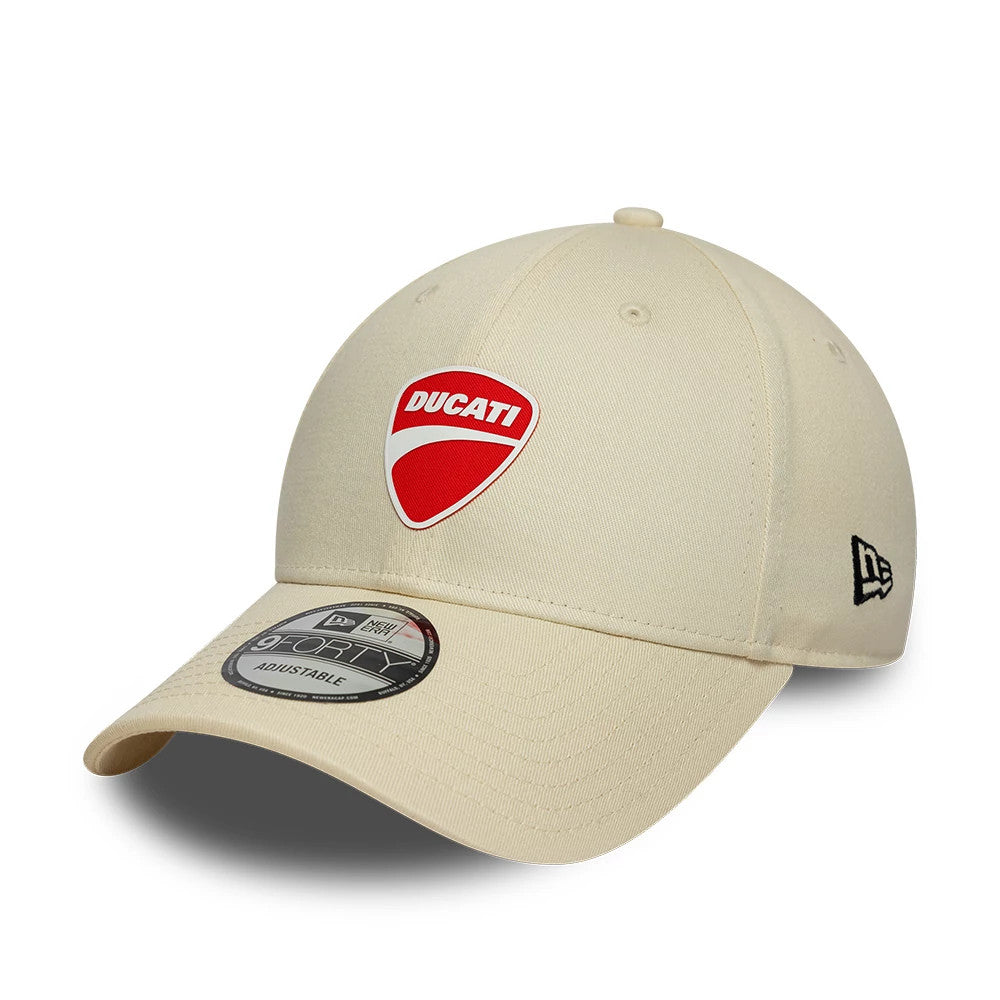 Ducati Motor Core Cream New Era 9FORTY Adjustable Cap, three-quarter view showing the red and white Ducati logo embroidered on the front panel, a pre-curved cream visor with a 9FORTY size sticker, and the black New Era flag logo on the left side.