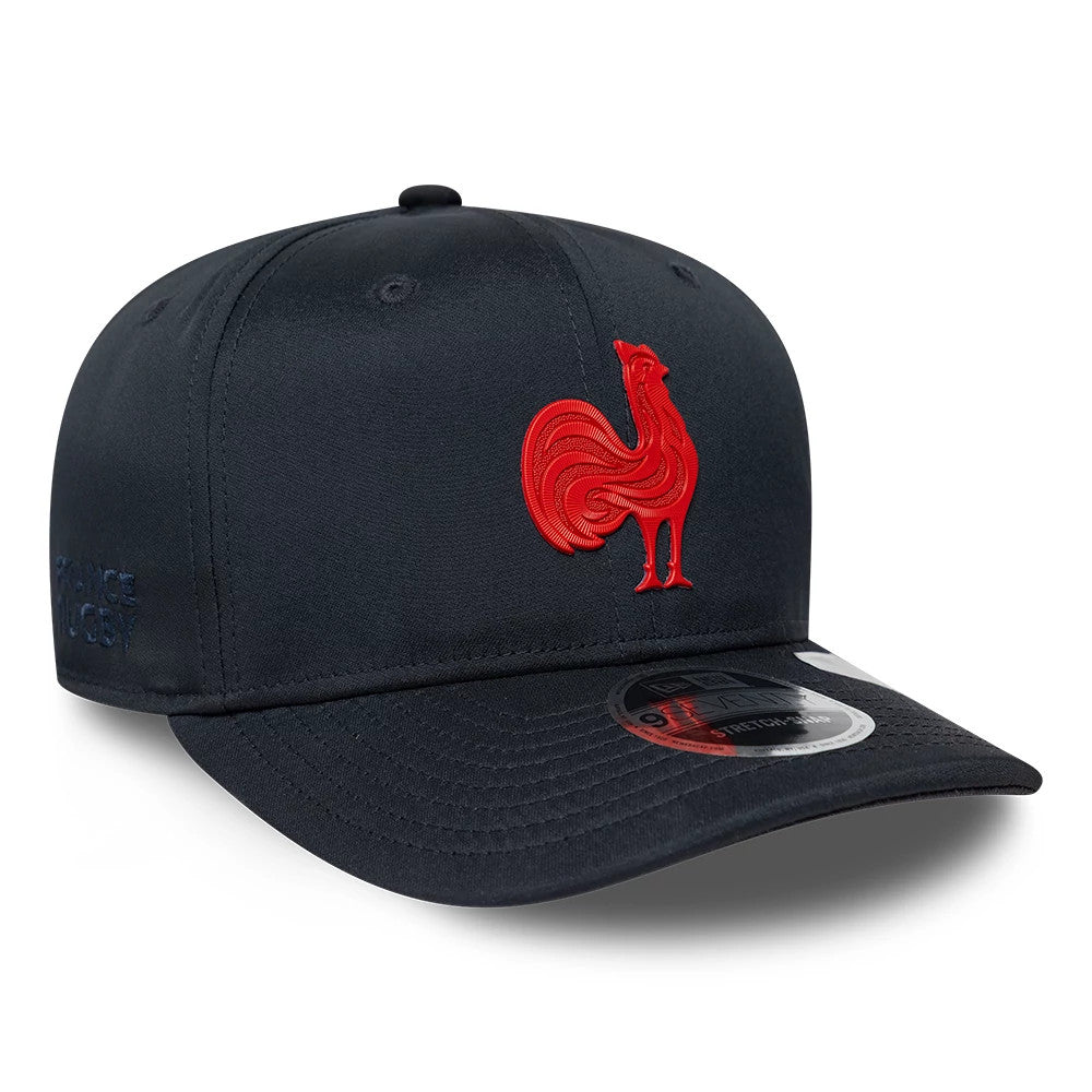 French Federation Of Rugby Kit Navy New Era 9SEVENTY Stretch Snap Adjustable Cap, three-quarter view showing the red embroidered rooster logo on the front panel, a navy visor with a 9SEVENTY size sticker, and France Rugby text on the left side.