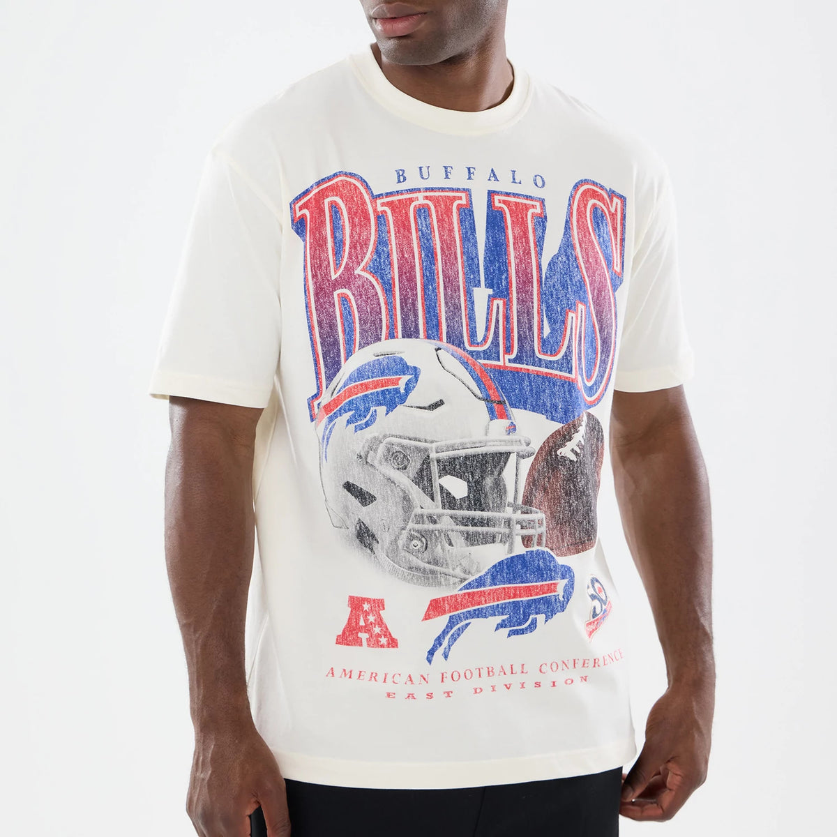 New Era Buffalo Bills NFL Sport Classic Cream T-Shirt, front view on-model displaying a large, distressed red and blue Bills graphic across the chest with a detailed football helmet illustration.