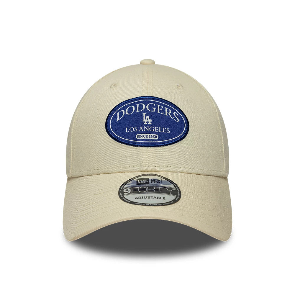 LA Dodgers MLB Patch Cream New Era 9FORTY Adjustable Cap, front view showing a large blue embroidered patch with white Dodgers Los Angeles text on the structured cream crown, curved visor and a 9FORTY size sticker on the visor.