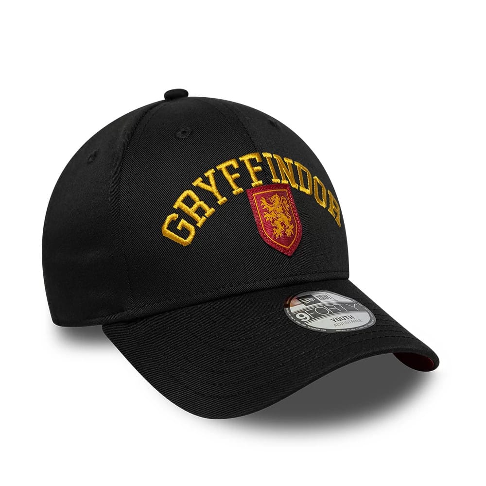 Youth Harry Potter Gryffindor Black New Era 9FORTY Adjustable Cap, three-quarter view showing the gold embroidered Gryffindor lettering and red and gold crest on the front panel, with a black curved visor and a 9FORTY size sticker on the visor.