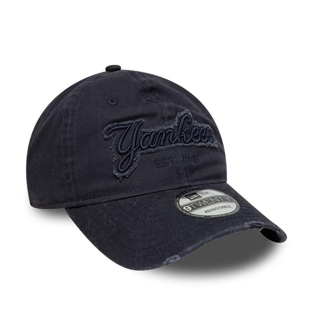 New York Yankees MLB Distressed Denim Navy New Era 9TWENTY Adjustable Cap, three-quarter view showing the navy embroidered Yankees script and EST. 1903 on the unstructured denim crown, distressed on the curved visor, and 9TWENTY size sticker.