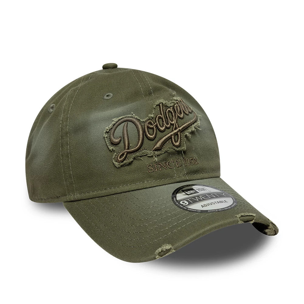 LA Dodgers MLB Distressed Denim Green New Era 9TWENTY Adjustable Cap, three-quarter view showing distressed brown embroidered Dodgers script logo on the front panel with a worn effect, a curved visor, and the 9TWENTY size sticker on the visor.