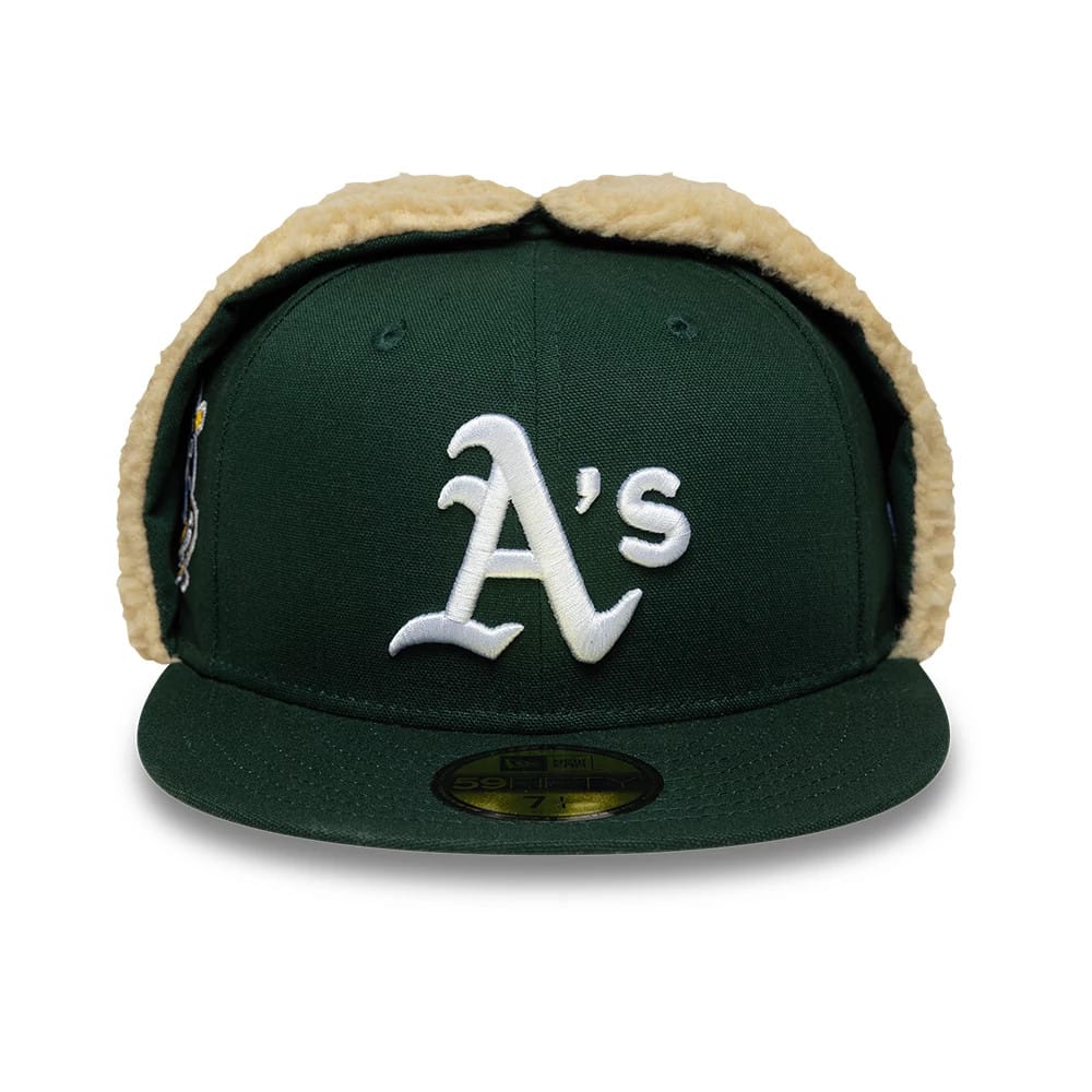 Athletics MLB World Series Dark Green New Era 59FIFTY Fitted Cap, front view showing the white A's logo in raised embroidery on the structured crown, with beige fleece dogears and a gold 59FIFTY size sticker on the flat dark green visor.