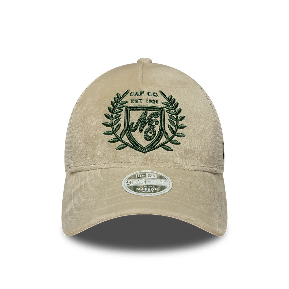 Womens New Era Velour Cream 9FORTY M-Crown A-Frame Trucker Adjustable Cap, front view showing a green embroidered NG crest logo with laurels on the soft cream crown, complemented by a 9FORTY size sticker on the cream curved visor.