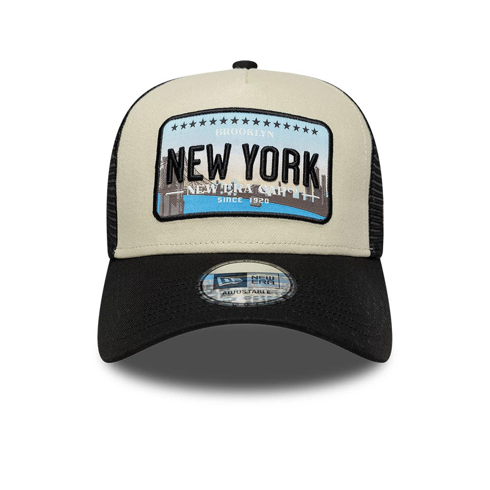 New Era Licence Plate Black New Era 9FORTY A-Frame Trucker Adjustable Cap, front view showing an embroidered beige and blue licence plate patch with black New York lettering, black mesh side panels.