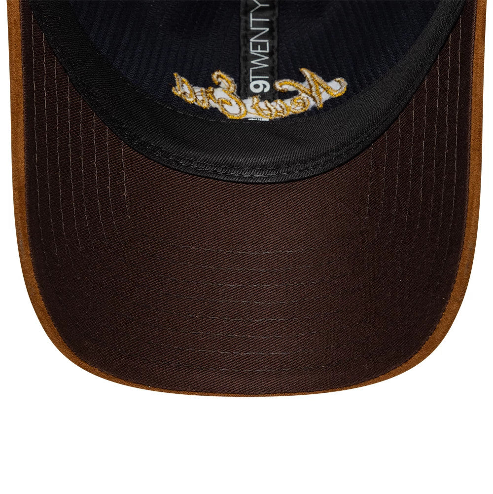 New Era Cord Mix Navy & Brown 9TWENTY Adjustable Cap, inside view showing a dark brown undervisor with a gold embroidered script on the edge, black sweatband, and 9TWENTY taping running across the centre inside the cap.