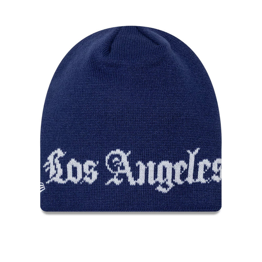 New Era LA Dodgers MLB Script Dark Blue Skull Knit Beanie Hat, front view showing white Los Angeles script in a gothic font across the lower edge of the dark blue knitted fabric, with the New Era flag logo on the right side.