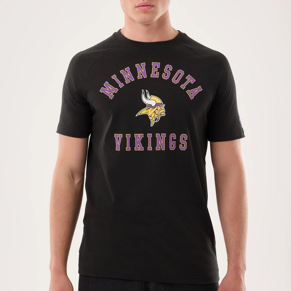 New Era Minnesota Vikings NFL Sideline 2026 Black T-Shirt, front view on a model featuring the purple and gold embroidered Minnesota Vikings lettering and logo across the chest, short sleeves, and a New Era logo on the left sleeve.