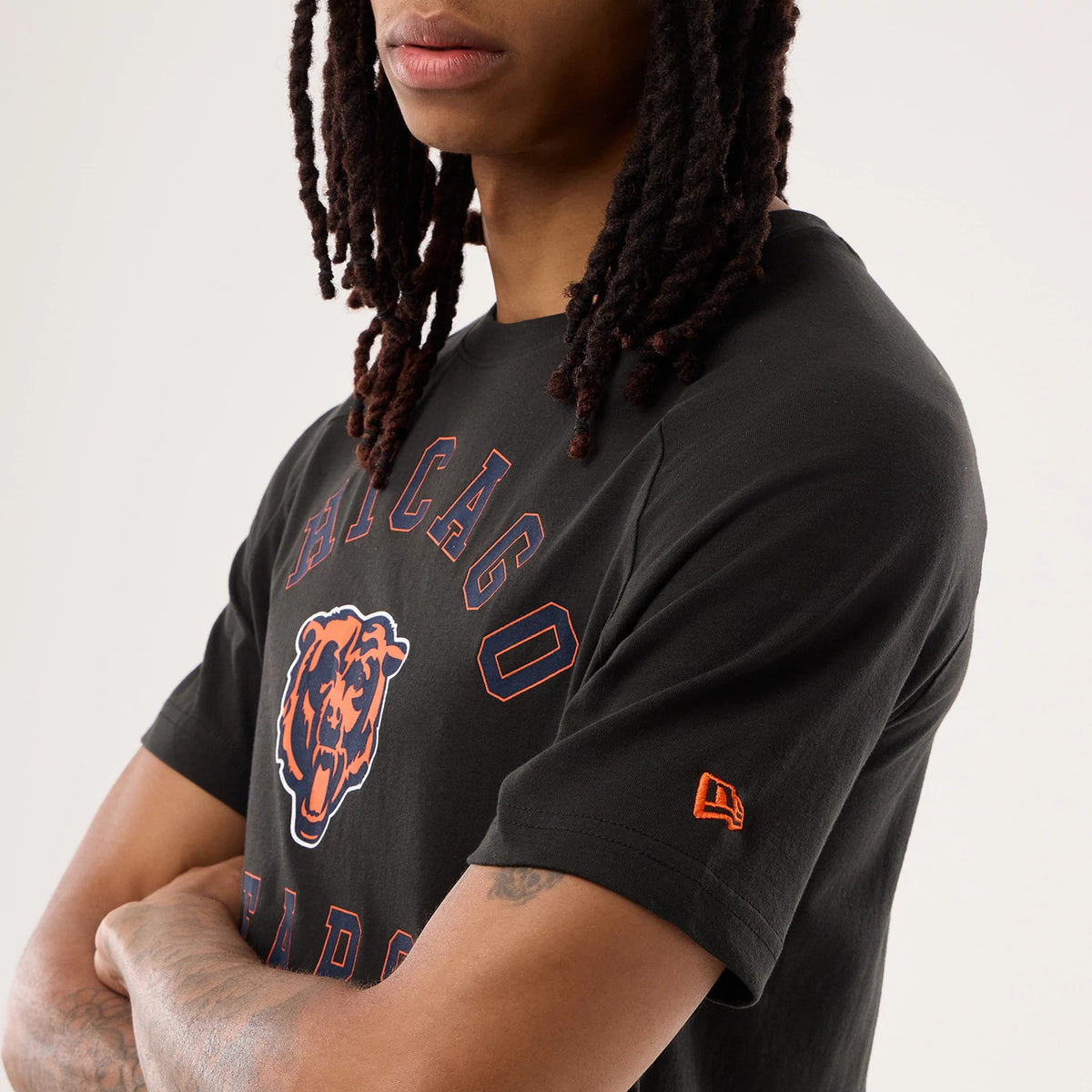 New Era Chicago Bears NFL Sideline 2026 Black T-Shirt, three-quarter view on a model showcasing the orange Chicago Bears graphic and lettering centred on the chest, with an embroidered New Era logo in orange on the left sleeve.
