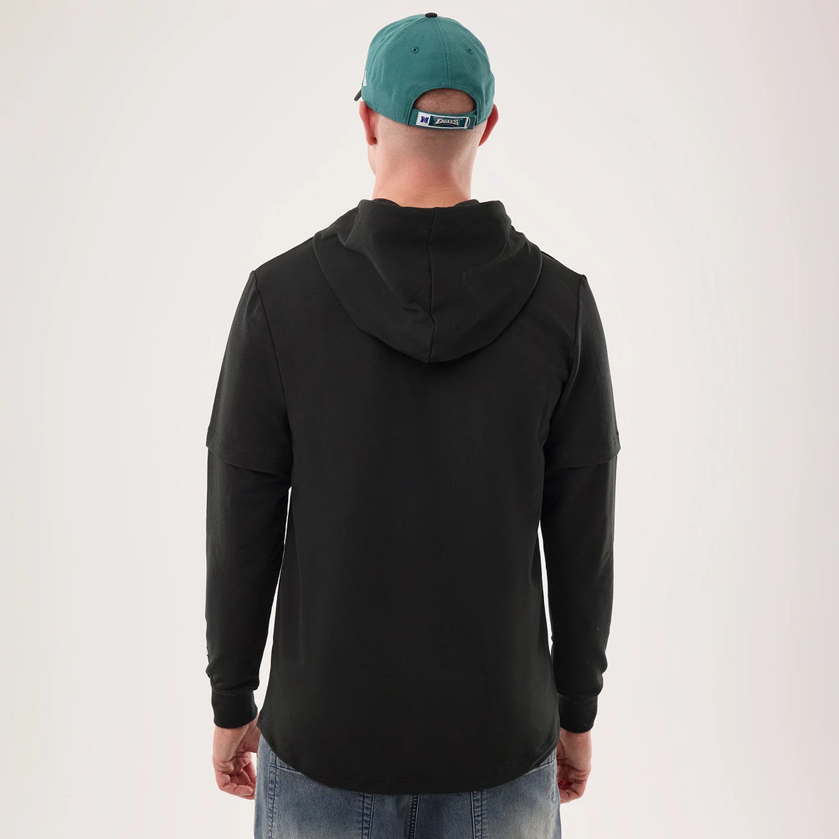 The model is wearing this NFL Sideline 2026 Philadelphia Eagles Double Sleeve Hoodie in black. 2