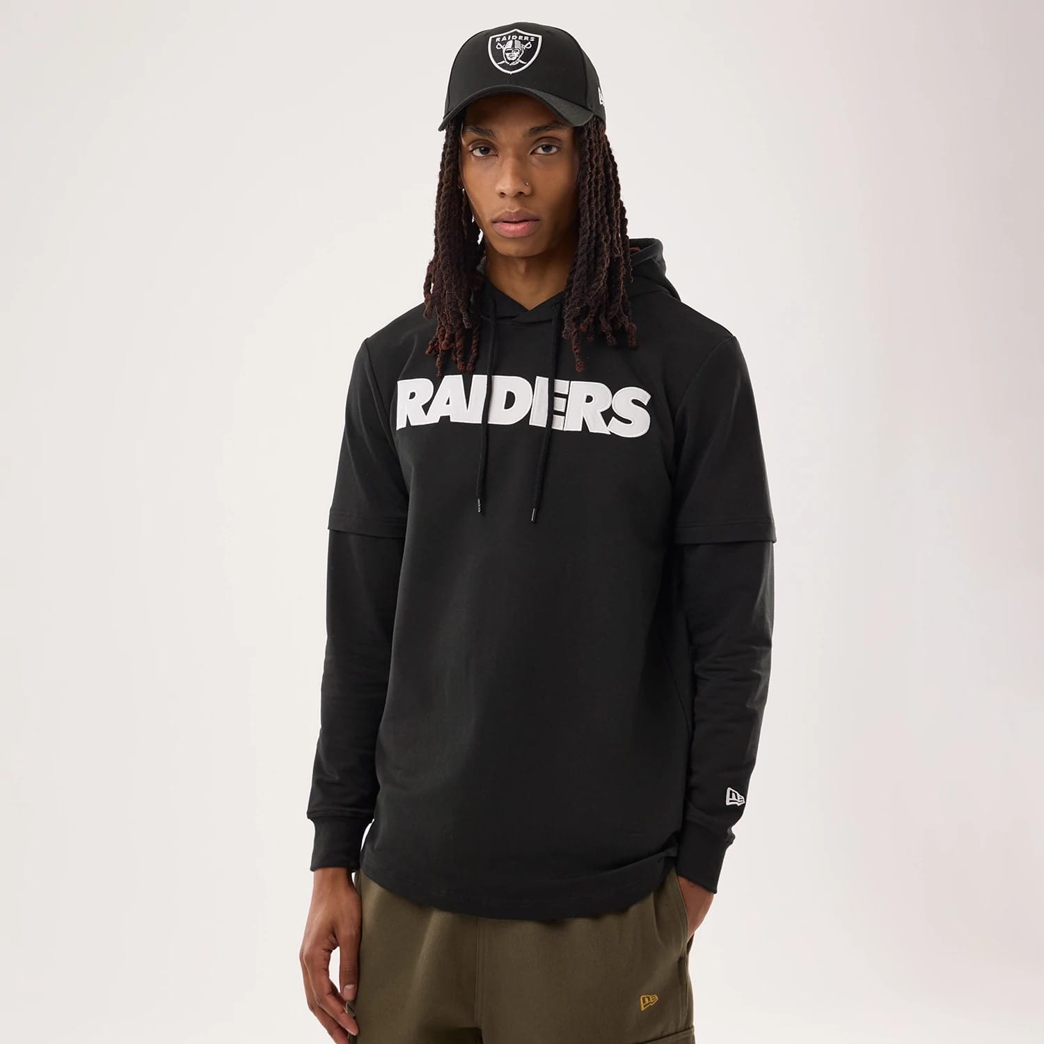 The model is wearing this NFL Sideline 2026 Las Vegas Raiders Double Sleeve Hoodie in black. 1
