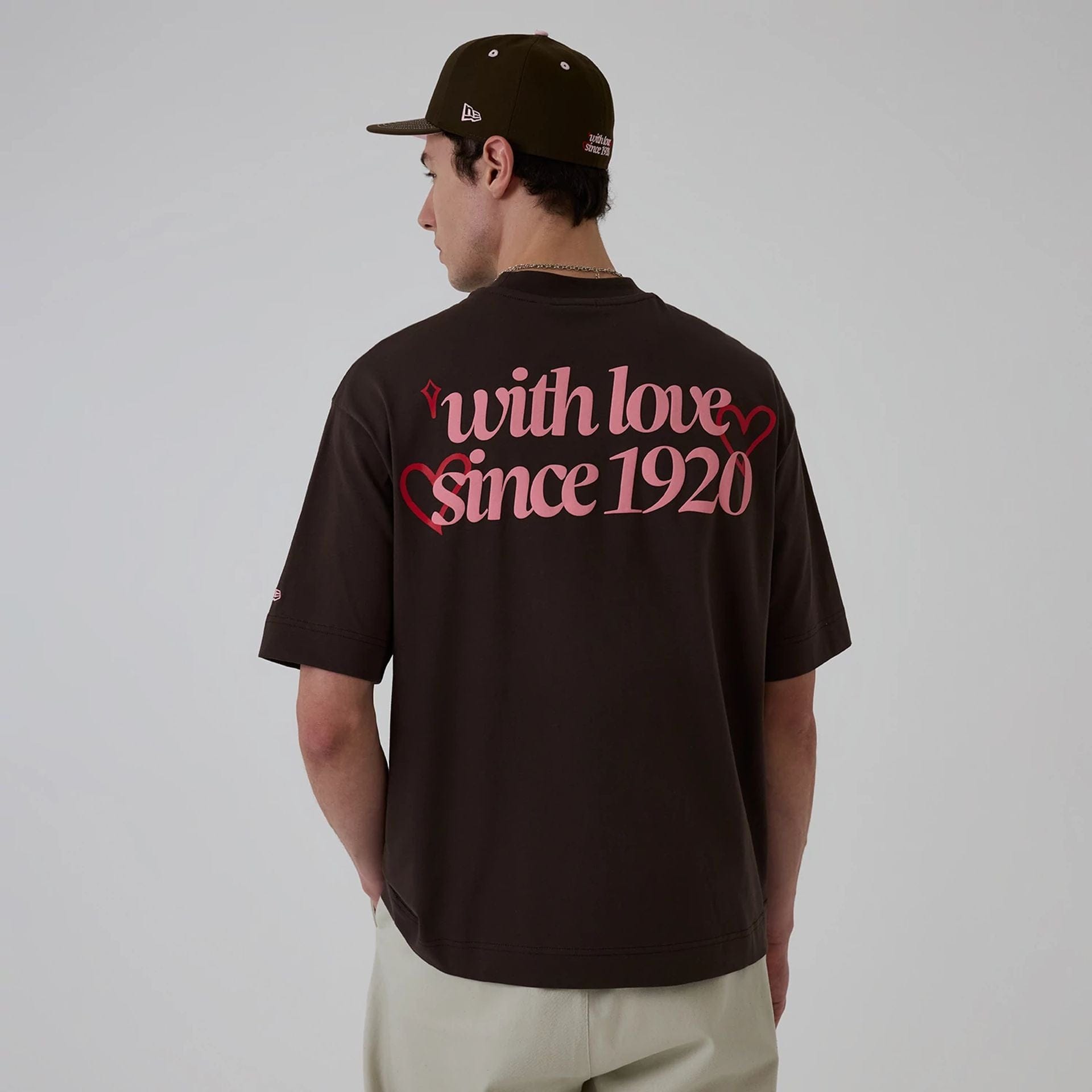 The model is wearing this New Era Love Graphic T-Shirt in dark brown. 2