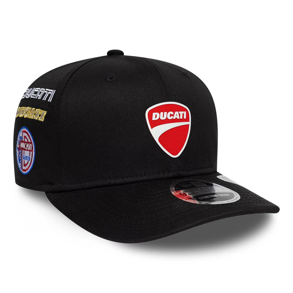 Ducati Motor Logo Patch Black New Era 9SEVENTY Stretch Snap Adjustable Cap, three-quarter view showing the raised red and white Ducati shield logo on the front panel, with embroidered patches on the side.