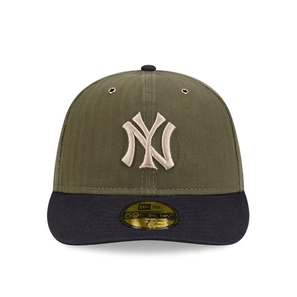New York Yankees MLB American Herringbone Green New Era 59FIFTY Fitted Cap, front view showing the raised beige NY logo on the structured green crown, contrasted by a black visor with a gold 59FIFTY size sticker on top.