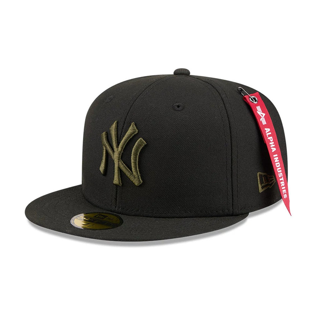 New York Yankees MLB X Alpha Black New Era 59FIFTY Fitted Cap, front view showing a raised olive green NY logo embroidered on the front panels, a flat black visor with a gold 59FIFTY size sticker, and a red Alpha Industries tag.
