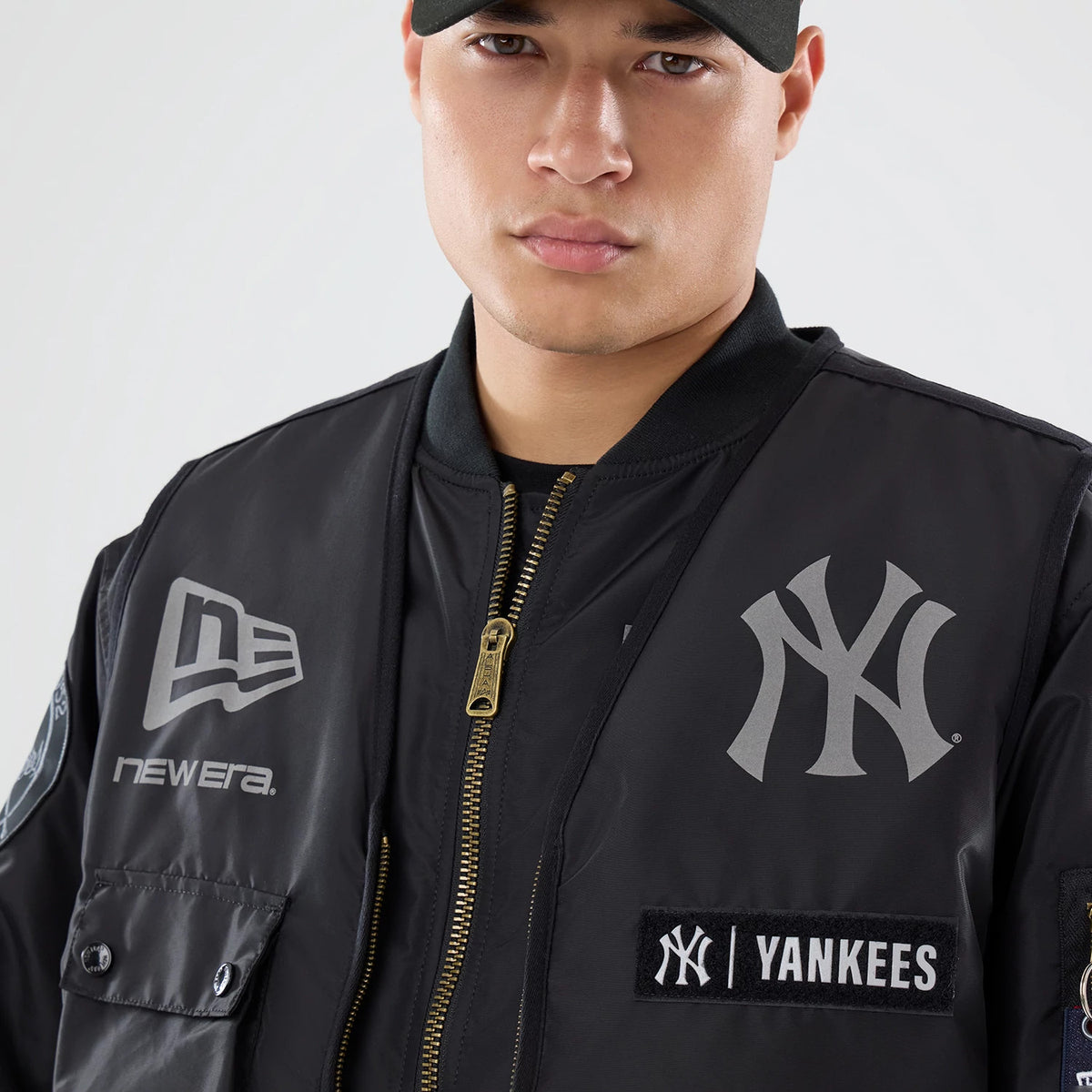The model is wearing this MLB X Alpha New York Yankees Bomber Jacket & Tactical Vest in black. 4