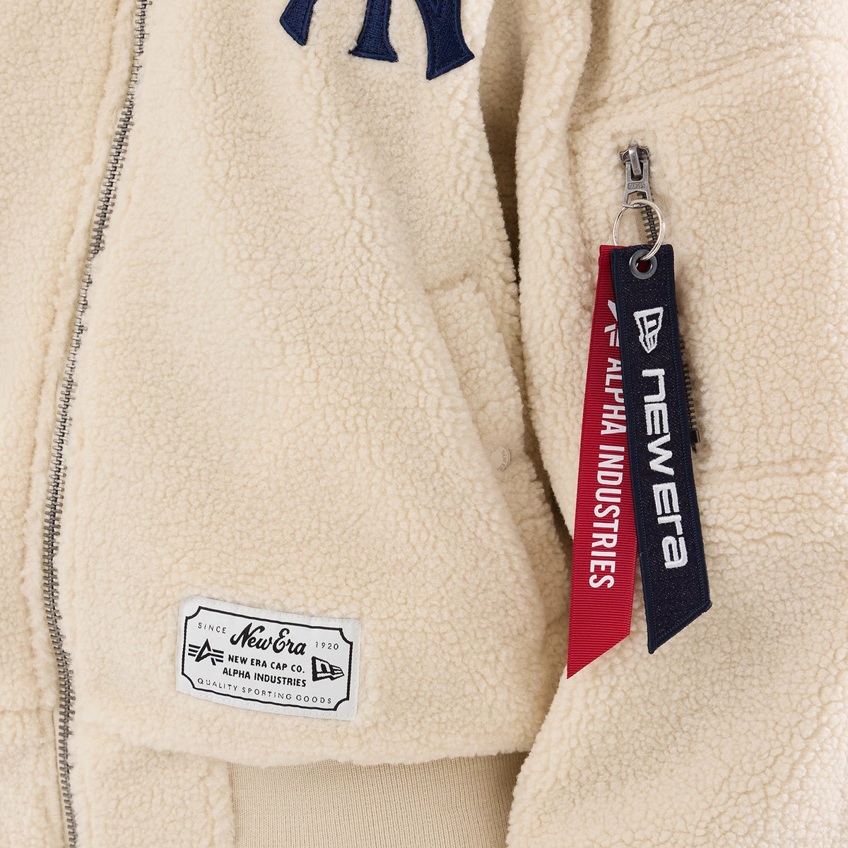 New Era New York Yankees MLB X Alpha Cream Borg Jacket, front view showing a navy embroidered NY logo on the chest, a silver zip running down the front, a sewn-on label near the hem, and New Era.