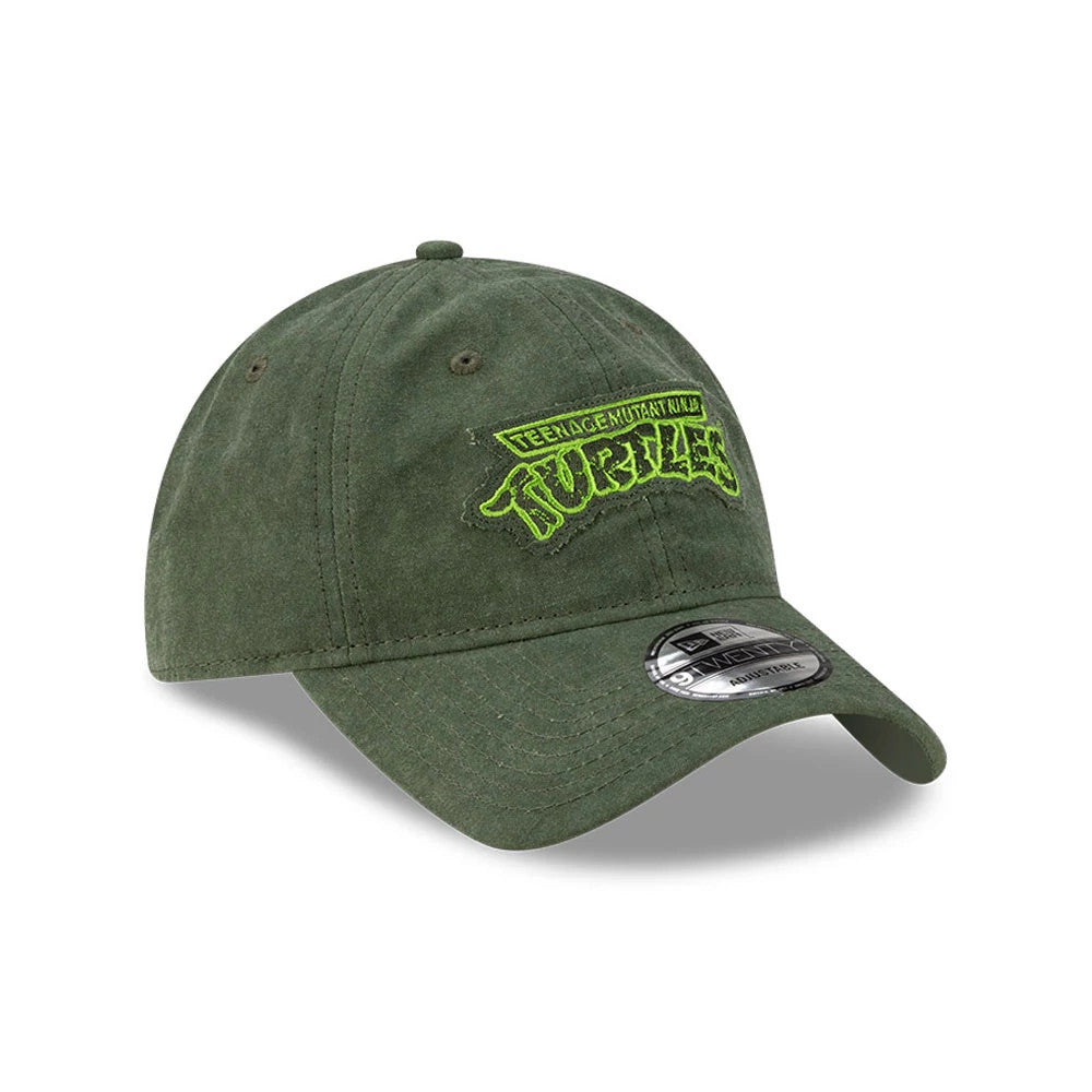 Teenage Mutant Ninja Turtles Dark Green New Era 9TWENTY Adjustable Cap, three-quarter view showing a neon green embroidered Turtles logo on the front panel, with a curved visor and a 9TWENTY size sticker on the dark green fabric.