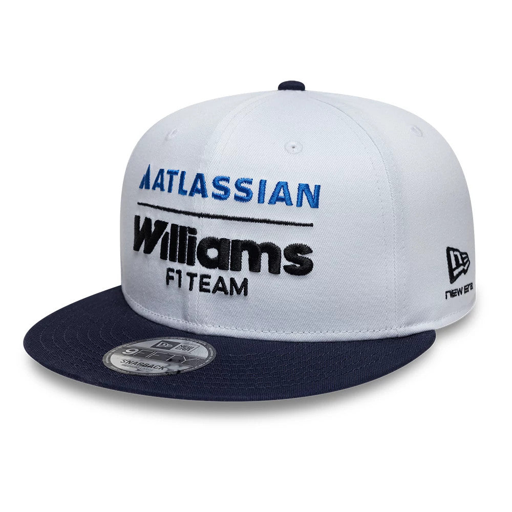 Williams Essential White New Era 9FIFTY Snapback Adjustable Cap, front view showing blue Atlassian and black Williams F1 Team lettering embroidered on the white crown, with a navy flat visor and the New Era logo on the left side.