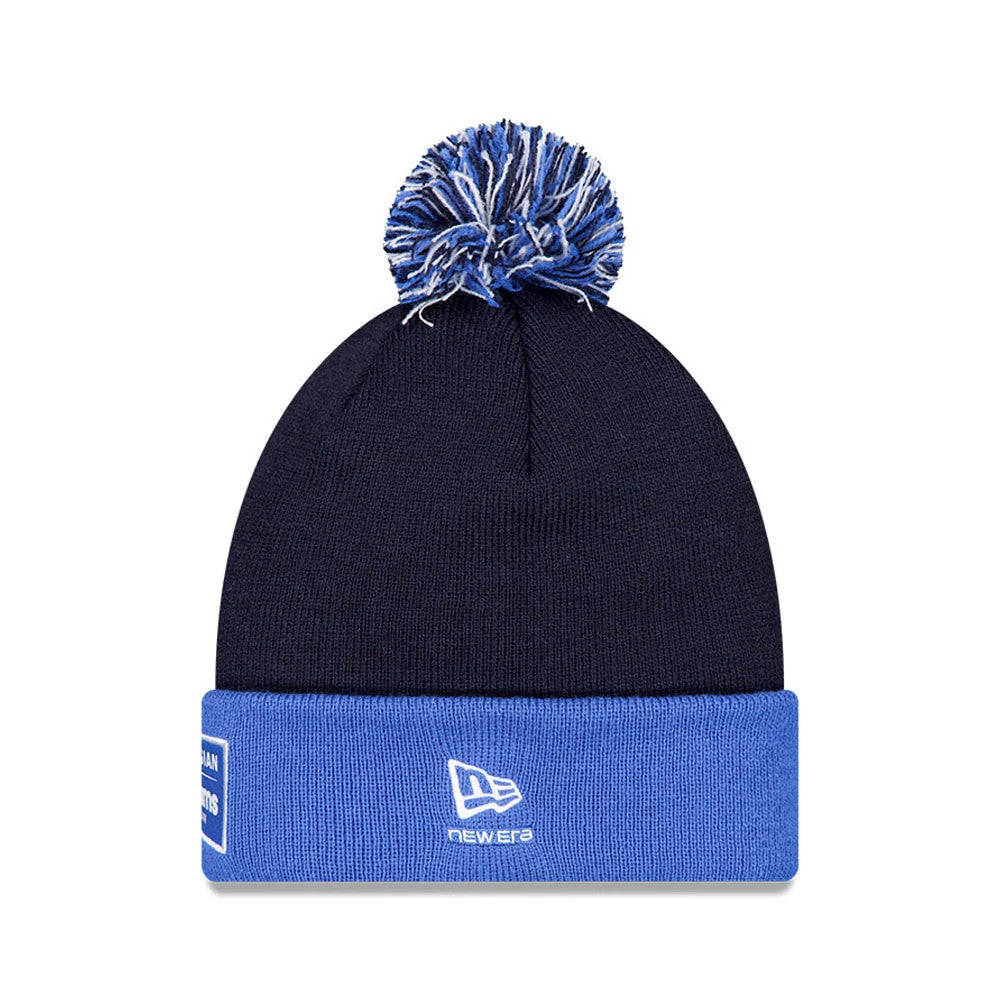 New Era Williams Essential Navy Bobble Knit Beanie Hat, front view showing a two-tone blue and white bobble on top, featuring an embroidered New Era flag logo on the folded blue cuff, with a patterned patch on the side.