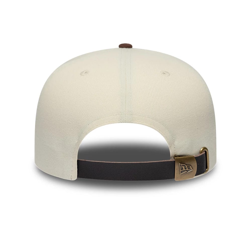 New Era Suede Visor Cream 9FIFTY A-Frame Adjustable Cap, rear view showing the bronze adjustable buckle and black strap, with the New Era flag logo embossed on the clasp, and a cream structured crown topped with a brown button.