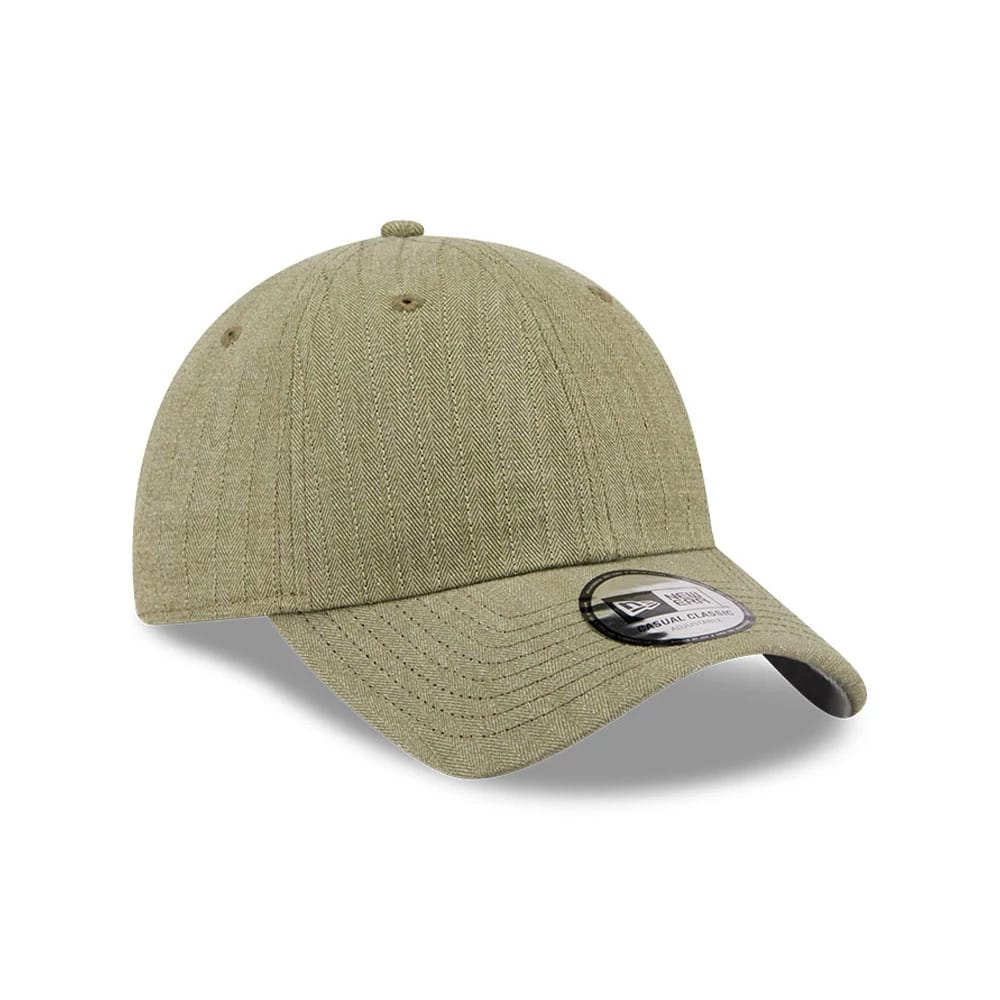 New Era Herringbone Pinstripe Green Casual Classic Adjustable Cap, three-quarter view showing a herringbone pattern on the crown and visor, complete with a black and white New Era Casual Classic size sticker on the curved green visor.