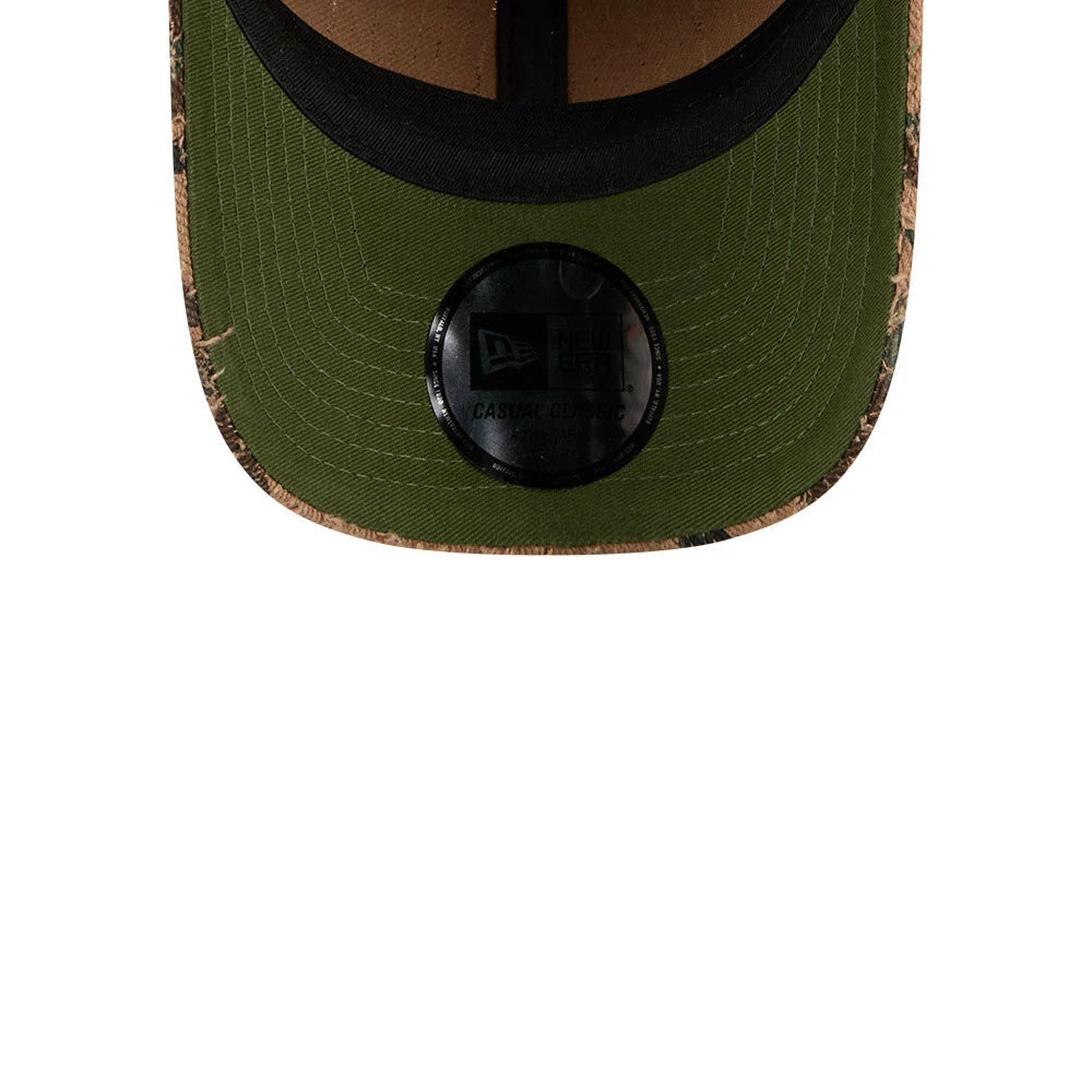 New Era Camo Casual Classic Adjustable Cap, inside view showing a green undervisor with a circular black New Era Casual Classic sticker at the centre, surrounded by camouflage pattern on the visor edge, alongside a black internal sweatband.