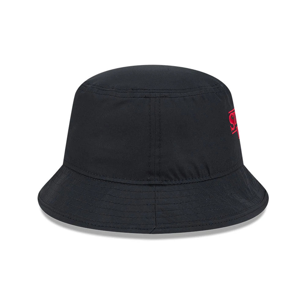 New Era Netflix Stranger Things Black Bucket Hat, side view showing the red embroidered Stranger Things logo on the left side, with a soft black crown and a downward sloping visor featuring stitching for added detail.