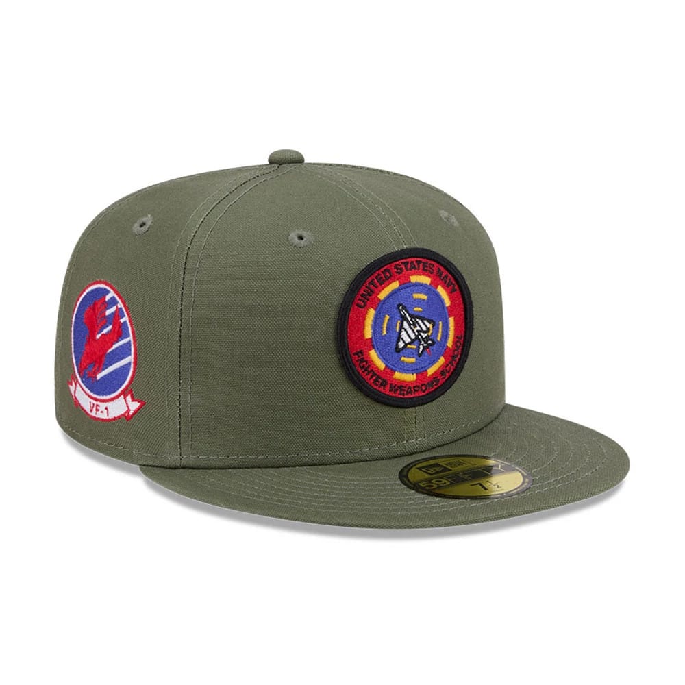 Top Gun Green New Era 59FIFTY Fitted Cap, three-quarter view showing the circular embroidered Fighter Weapons School patch on the front panel, a VF-1 logo on the right side, and a flat green visor with a gold 59FIFTY size sticker.