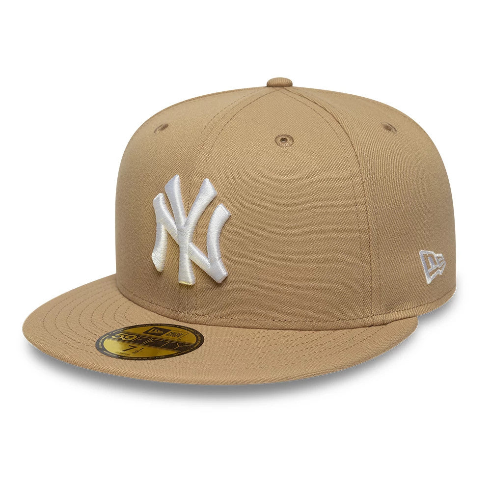 New York Yankees MLB League Essential Light Beige New Era 59FIFTY Fitted Cap, three-quarter view showing the white raised NY logo embroidered on the front panel, gold 59FIFTY size sticker on the flat visor.