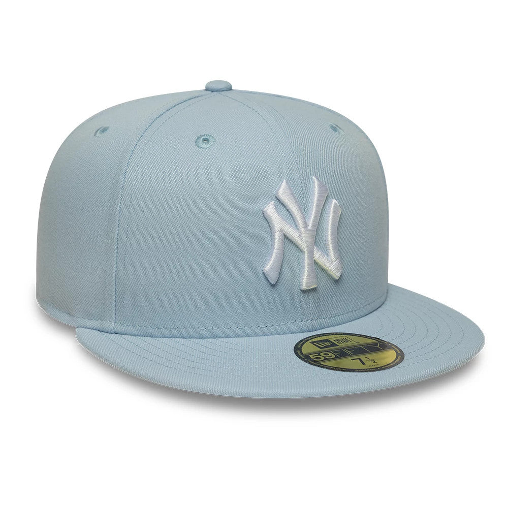 New York Yankees MLB League Essential Pastel Blue New Era 59FIFTY Fitted Cap, three-quarter view showing a raised white embroidered NY logo on the front panel, pastel blue flat visor with a gold 59FIFTY size sticker, and matching top button.