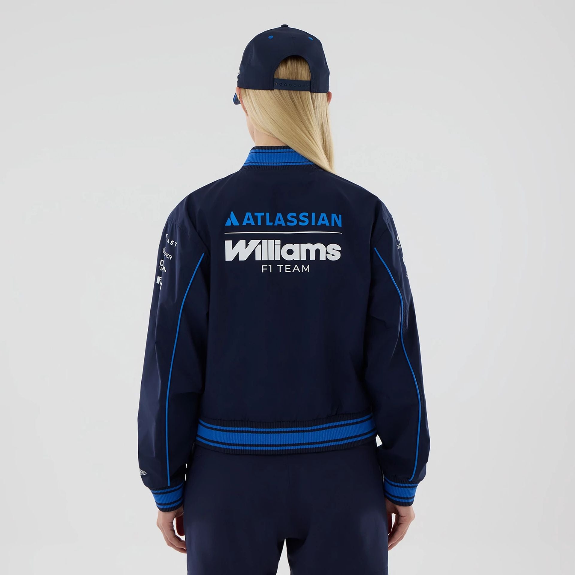 The model is wearing this Womens Atlassian Williams F1 Team Varsity Jacket in navy. 2