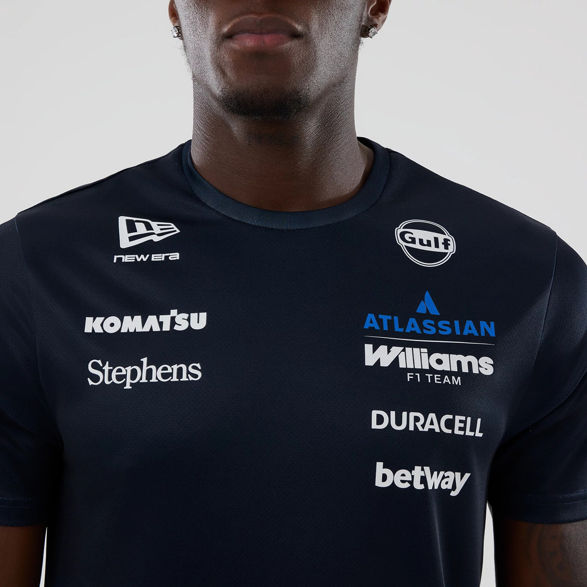 New Era Williams Alex Albon Navy Tech T-shirt, front view on-model showing multiple sponsor logos including a white printed New Era logo on the right shoulder, Gulf logo on the left chest.