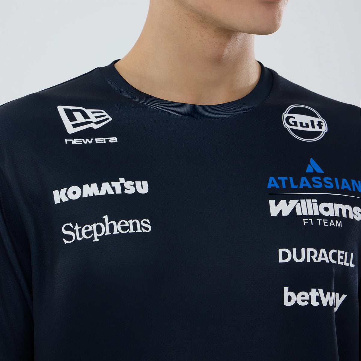 New Era Williams Navy Tech T-shirt, front view showing multiple white logo prints including New Era near the left shoulder, Komatsu and Stephens along the chest, with Gulf and Atlassian logos positioned above the Williams F1 Team print.