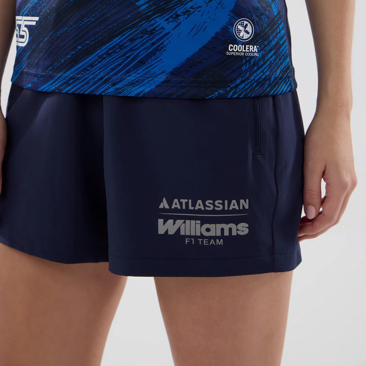 New Era Williams Womens Carlos Sainz Navy Tech T-shirt, front view on a model showing the detailed blue and black graphic design on the upper section, with a white embroidered team logo near the hem.